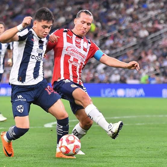 Disputa del balón en un partido entre Chivas y Rayados
